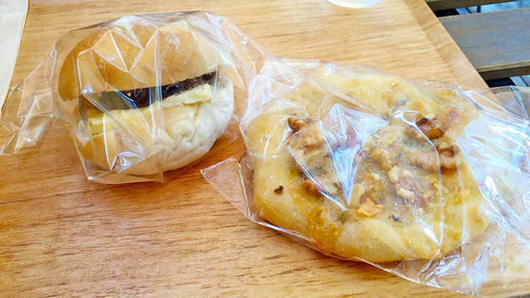 パンとcafé えだおねの人気商品のあんバター(写真左)、蜂蜜の甘さとチーズ・クルミの塩気が絶妙のタルトフランベ(写真右)