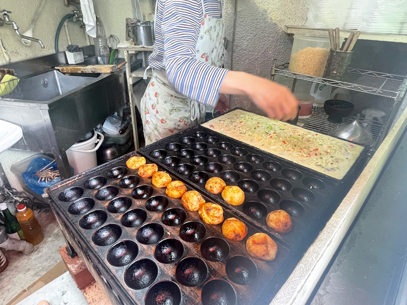 「たこ坊 宮坂店」のたこ焼きを焼く様子